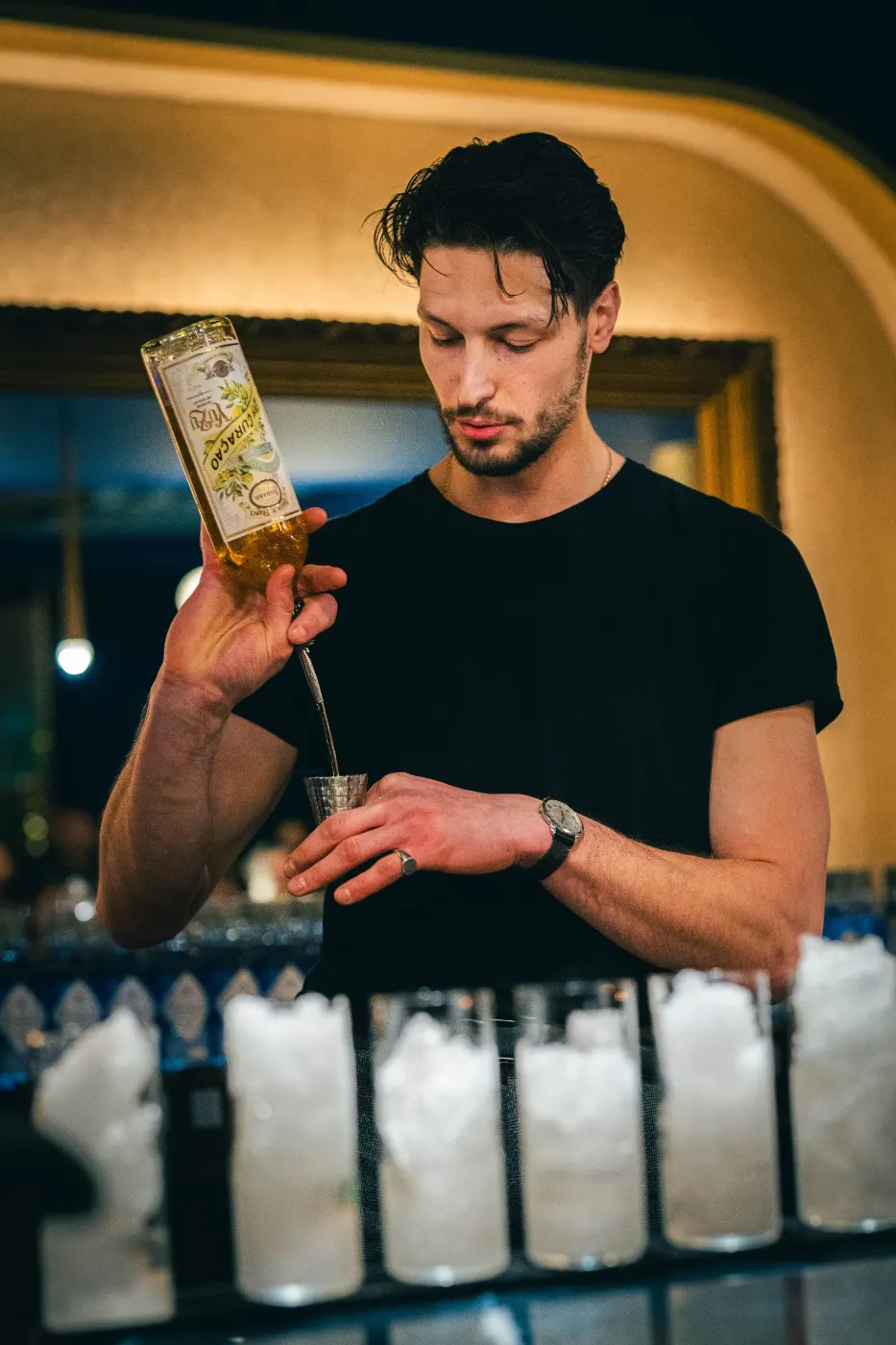 Bartender qui verse du Curaçao Yuzu Ferrand dans un jigger